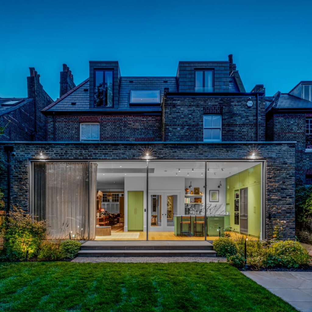 silver sliding doors with no frames installed brick built extension in London